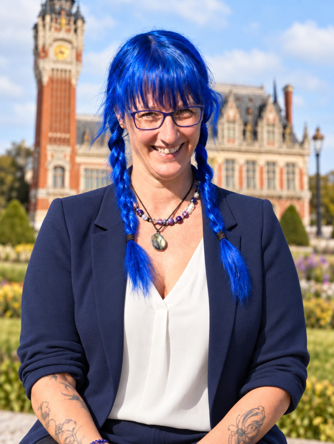 Portrait de Séverine Duflos, accompagnante périnatale à Boulogne-sur-Mer, souriante face à la mer, vêtue d’une blouse bleue.